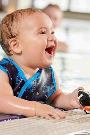baby in a water babies wrap in the pool with inky the fish